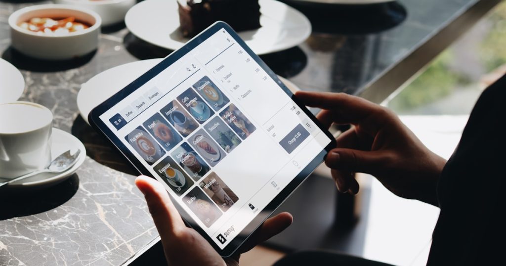 A person sitting at a table with a tablet
