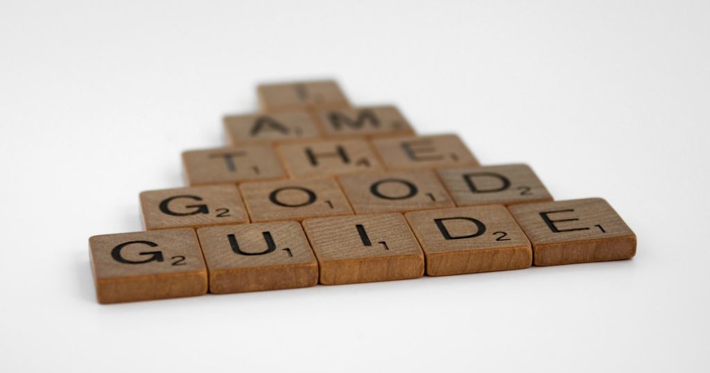 a wooden scrabble with the words i am the good guide on it